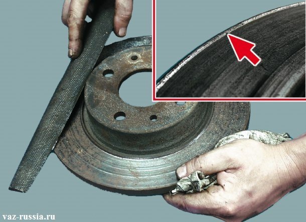 Удаление при помощи напильника буртика, который со временем образуется на диске и указан он ещё стрелкой на маленьком фото